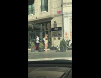 Woman in white outfit walks  on the sidewalk