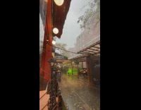 Outdoor dining area has rain and hail on sidewalk 