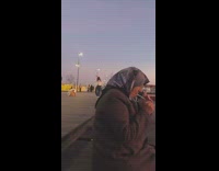 Woman in white top tiktok dance by the beach at sunset