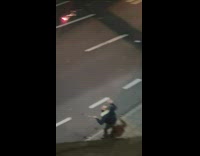 Guy lights a sparkler and jumps on street 