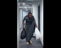 Guy wearing a trashbag pretending to be a balenciaga runway model 