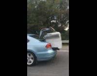 Washer hanging out car trunk only secured by tape