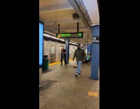 Guy playing trombone kicks pole subway station