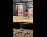 Man dancing on subway platform while waiting for train
