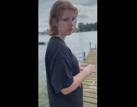 Girl on dock is feeding them in water 