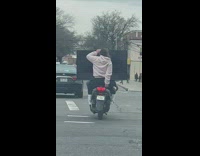 Lady Holds Up Smart Television on Motorcycle