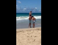 Man carries woman for photo at beach