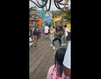 Four people dance on the docks while a kid watches