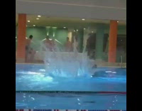 Guy jumps high off diving board and does backflips into indoor pool
