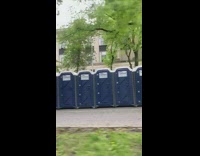 Large amount of blue porta pottys on sidewalk 
