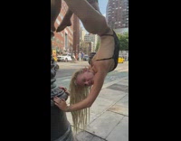 Dancer swings upside down from pole 