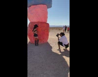 Black skirt girl poses stacked painted rocks 