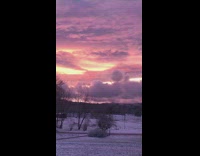 Clouds float across pink purple sky sunset 