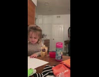 Little girl says to eat dinner and play, laughs at dad squatting with baby carrier then falls off chair