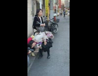 Four women with their dogs take pictures on the street
