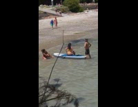 Woman adjust thong sit paddle board beach