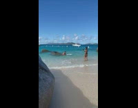 Man feet up pose beside rock beach