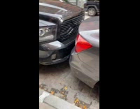 Cars are parked so closely they touch 