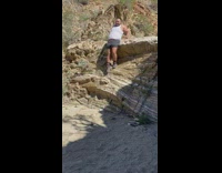 Guy tries to step down from tall rock