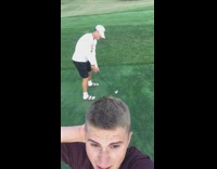 Guy tees off almost hits friends head with golf ball on course red shirt slow motion