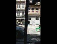 Woman in green suit sits in the middle of the street