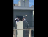 White shirt black guitar guy grey building 