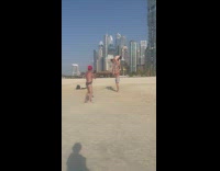Two men hold hands stand on shoulder beach