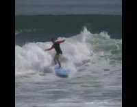 Guy in pink black wet suit surfboard slapping wave