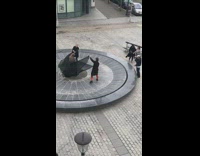 Lady wearing a black dress poses on fountain