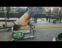 Guy balancing on bar lands on weight plate 