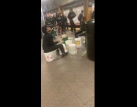 Two men bucket drum battle in subway station