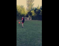 kid in red and black kicks ball lands on back neck