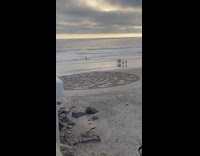 Bearded man draw beach sand circular art