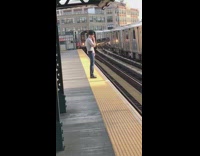 Man black hat standing on yellow line incoming train