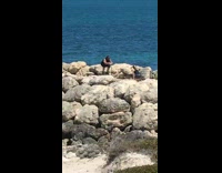 Guy films exercise video at beach 