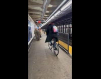 Person ride bike on subway station platform.