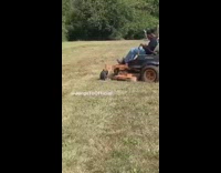 Guy driving lawn mower on grass driving in circles