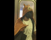 Person in subway train wearing a cartoon bear blanket
