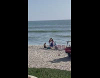 Woman in black swimsuit jumps at beach 