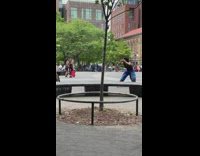 Artist in Colorful Costume Poses for Photo with Homeless Guy 