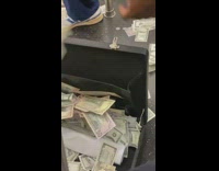 Guy stuffs money into safe 