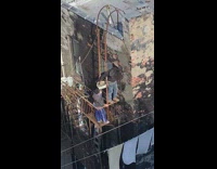 Two guys applying concrete patch to building with hands