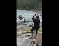 Girl photographs red beanie friend waterfall rock 