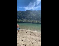 Guy on shore throws football at his friend in speedboat
