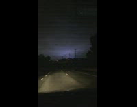 Drives along the highway and takes video of thunder lightning 