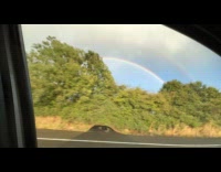 Double rainbow driving view from car window