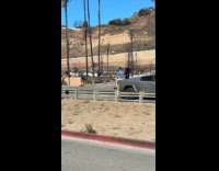 Man sits on Cybertruck for photo aftermath behind
