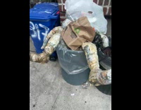 Paper man sits in trash 