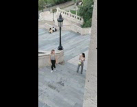 Woman gray top walks up stairs looks on camera
