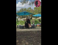 Two women in black dress outfit selfie at the park